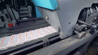 报纸在印刷厂的传送带上移动。打印设备。视频素材模板下载