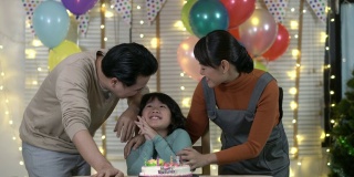 亚洲人一起吹蜡烛和生日蛋糕。快乐的家庭时光。节日的概念，新年和圣诞节。4 k决议。
