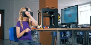 8-9岁女孩使用虚拟现实眼镜在学校课堂上探索3D虚拟现实。