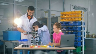 工程师在科学俱乐部教孩子们创新机器人技术。视频素材模板下载