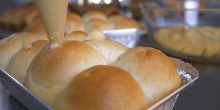 厨师烘焙烘焙，将奶油芝士放入小圆面包或面包中。