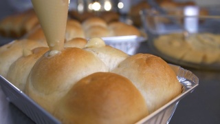 厨师烘焙烘焙，将奶油芝士放入小圆面包或面包中。视频素材模板下载