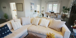 一个舒适的家庭客厅，白色的墙壁和深色的木地板，手持