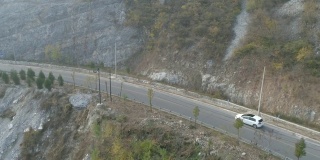 鸟瞰图白色汽车行驶在山间小路上。中国