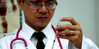 医生用注射器从药瓶中吸药治疗病人