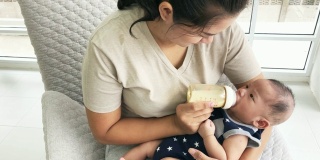 亚洲母亲正在喂她刚出生的男婴