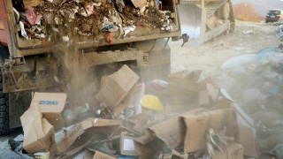 垃圾车在垃圾填埋场倾倒垃圾。把垃圾变成垃圾的车辆视频素材模板下载