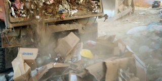 垃圾车在垃圾填埋场倾倒垃圾。把垃圾变成垃圾的车辆