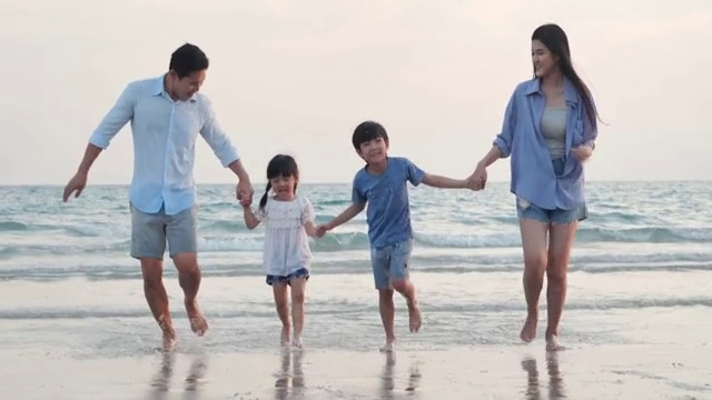 幸福的一家人在海滩上散步。快乐的一家人在海滩上享受暑假。假期——iStock