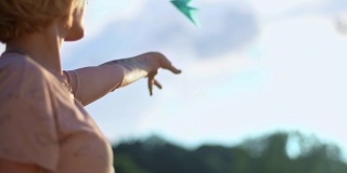 一个手上有纹身的年轻美丽的女孩正在放飞一架纸飞机。