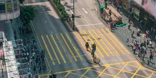 在中国香港尖沙咀区，人们和出租车穿过一个非常繁忙的十字路口