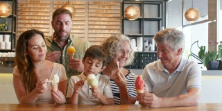 拉丁美洲一家三口在冰淇淋店微笑着享用冰淇淋