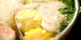 CU手持相机泰式火锅风格，各种食材水煮，甜玉米，中国芹菜。