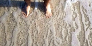Waves splashing over feet