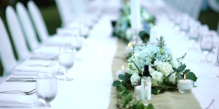 在浪漫的户外婚礼桌上，鲜花和蜡烛放在桌子上。