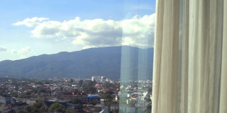 白天从窗口拍摄到城市和后面的山。