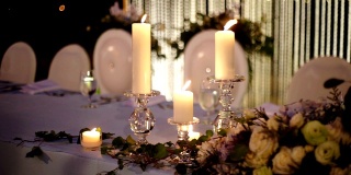 浪漫的户外婚庆桌，桌上摆放鲜花和蜡烛，背景模糊。
