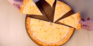 人们拿着玛格丽塔披萨上不同种类的奶酪在木板上特写俯视图。