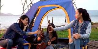 特写镜头:三个女人花周末时间在海边露营日落
