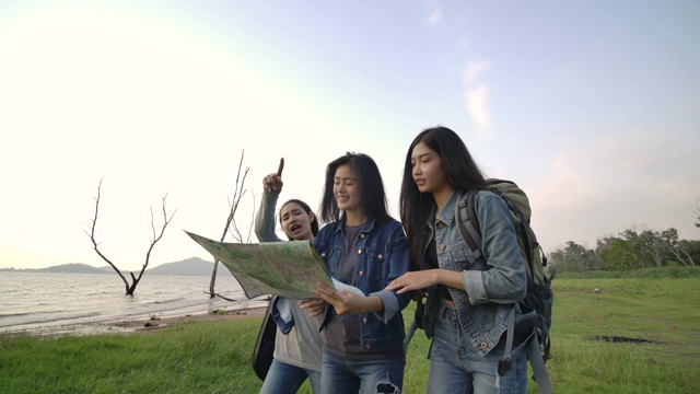 慢动作-一群年轻的亚洲女孩在乡村徒步冒险。在树林里露营的徒步旅行者。旅行和友谊的概念。