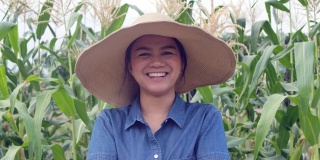 快乐和骄傲的妇女农民微笑交叉手臂在农田在泰国日落