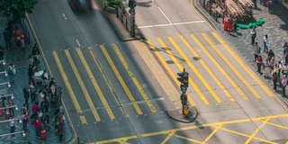 在中国香港尖沙咀地区，人们和出租车穿过一个非常繁忙的十字路口