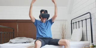 年轻的亚洲男人用虚拟现实眼镜与幸福的卧室，人在幸福的时刻，生活方式，人和技术