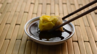 蒸猪肉饺子用木筷子夹，蘸酱油视频素材模板下载