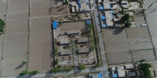 鸟瞰图小的小贫困村庄与学校在旱地中间，甘肃，中国