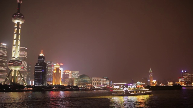 夜景浦东堤岸，灯火通明的游船在黄浦江上航行，