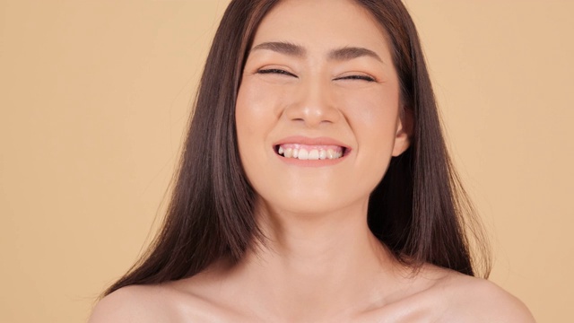 美丽的亚洲女人的肖像看着相机迷人的微笑。具有美容护肤理念的人。