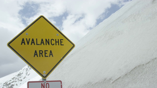 “雪崩地区”警告路标在科罗拉多州的落基山脉下阴天在冬天