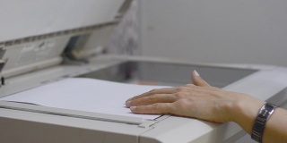 办公室里的女孩用复印机扫描文件