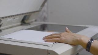 办公室里的女孩用复印机扫描文件视频素材模板下载