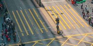 在中国香港尖沙咀区，人们和出租车穿过一个非常繁忙的十字路口