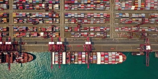 航拍俯视图集装箱货轮在城市进出口业务及物流国际货物。由起重机运往香港维多利亚港。