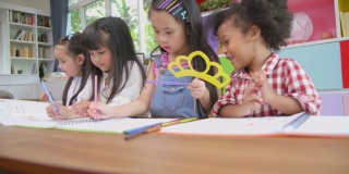 一群多元化的孩子在家庭学校的桌子上玩耍和画画，儿童多元化教育理念，国际学校，倾斜拍摄。