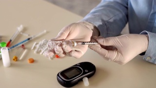 一个女人拿起胰岛素注射器的特写。视频素材模板下载