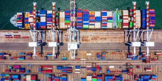 深海港口集装箱船装卸，远洋集装箱船物流进出口运输业务高空俯视。