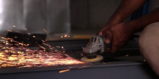 工人用磨床切割金属。磨铁时的火花高清视频。