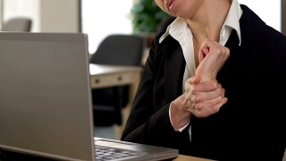 在笔记本电脑上打字的女性经理患有手腕疼痛和腕管综合症视频素材模板下载