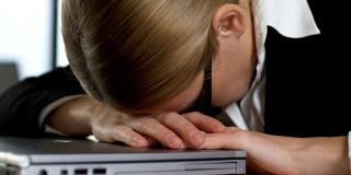 压力大的女经理关闭笔记本电脑，感到沮丧，工作超负荷