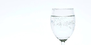 Pouring soda water into a clear glass.