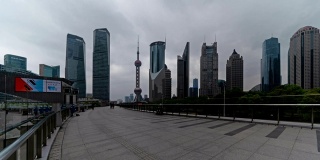 人们在上海市中心的人行道上行走的时间流逝。亚洲智慧城市的金融区和商业中心。日落时分的摩天大楼和高层办公大楼。