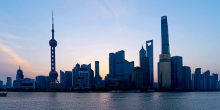 中国黄浦江畔的上海市区天际线上的明珠，从夜晚到白天的时间流逝。智慧城市的金融区和商业中心。外滩附近有摩天大楼和高层建筑。