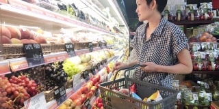 在超市买水果的女人。健康的生活方式的概念