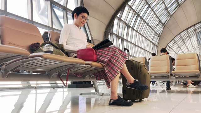 Asian woman using computer tablet at airport terminal