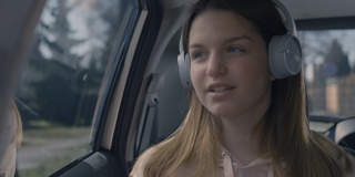 十几岁的女孩边开车边跟着音乐唱歌