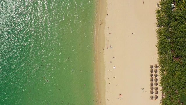 阳光明媚的三亚著名的大东海拥挤的海滩空中全景4k海南中国