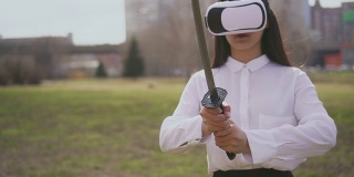 亚洲人骄傲地拿着武士刀，戴着特殊的未来眼镜玩虚拟现实游戏